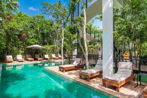 a pool with chaise lounge chairs and a resort at Spacious 3BR Close to Tulum Ruins, Beach & Town in Tulum