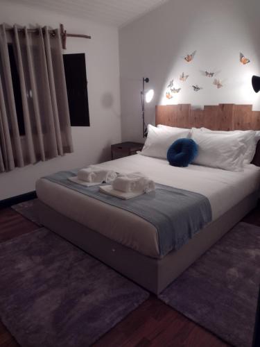 a bedroom with a large bed with two towels on it at Valentine's House in Óbidos