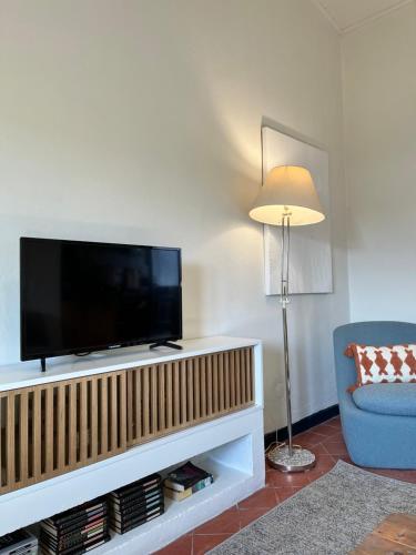 a living room with a television and a blue chair at Valentine's House in Óbidos