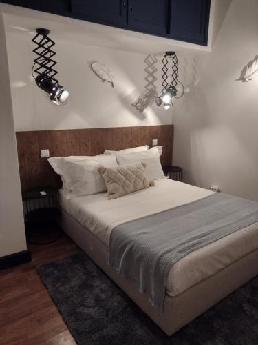 a bedroom with a large bed with lights on the wall at Valentine's House in Óbidos