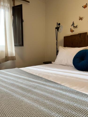 a bedroom with a bed with a blue pillow on it at Valentine's House in Óbidos