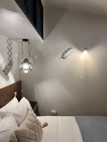 a bedroom with a bed with two lights on the wall at Valentine's House in Óbidos