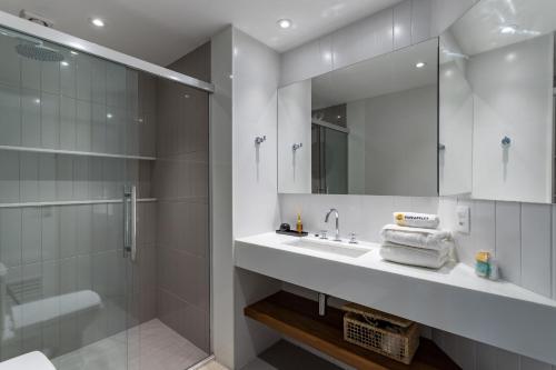y baño blanco con lavabo y ducha. en Conforto em Copacabana - 1 quarto - BR1307 Z3, en Río de Janeiro
