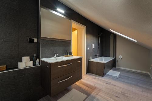 a bathroom with a sink and a bath tub and a mirror at Bördeapartment am Heiderand 