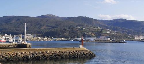 a body of water with a town and mountains in the background at Quintana&lev in Viveiro
