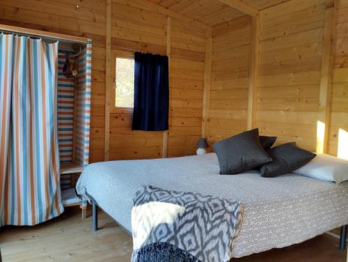 ein Schlafzimmer mit einem Bett in einem Blockhaus in der Unterkunft Agricampeggio la casa di Nicla in Cavriglia