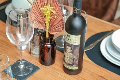a bottle of wine and a flower in a vase on a table at 2 Bed New York Style Loft Apartment Free Parking in Bradford