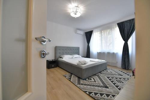 a bedroom with a bed and a window and a rug at Luxury Studio / M Romancierilor in Bucharest