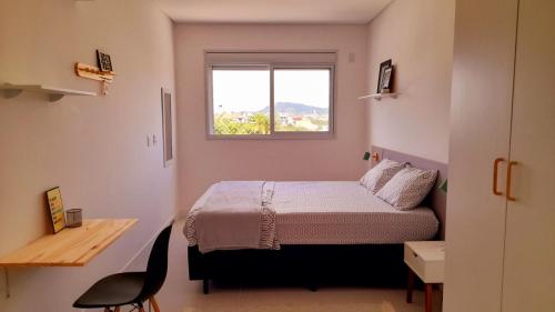 Habitación pequeña con cama y ventana en Apto Espetacular 180 m do mar, en Florianópolis