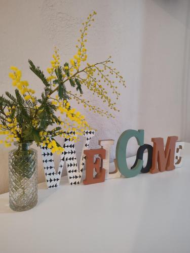 a vase of flowers on a shelf with a sign at Can Costals Olivo in Pals
