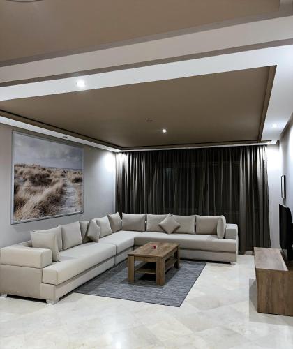 a living room with a white couch and a table at Hotel Appartement Tanger in Tangier
