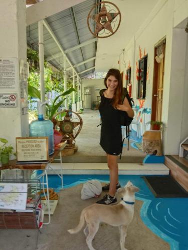 a woman standing next to a dog in a room at LightHaus DP Garden Resort in Siquijor
