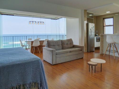 sala de estar con sofá, mesa y cocina en Apart Hotel com Maravilhosa Vista Mar na Barra de Tijuca B1-0024, en Río de Janeiro