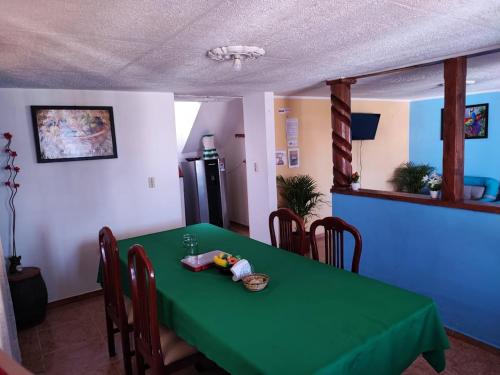 a green table in a room with a refrigerator at Alojamiento Chalet - Monguí in Monguí