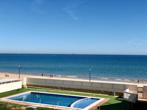uma piscina ao lado de uma praia e do oceano em Breathtaking Beachfront House em Sueca