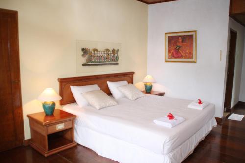 a bedroom with a bed with two white towels on it at Yeh Panes Hot Spring Resort in Penebel