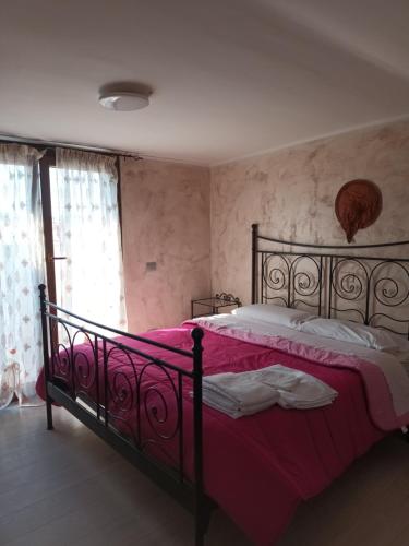 una camera da letto con un letto nero e una coperta rosa di Villa Mery a LʼAmericano