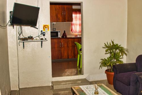 a living room with a tv on a wall at Guddy’s Riverside Cottage in Nausori