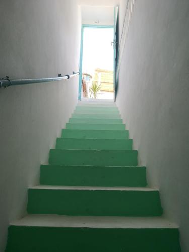 a stairway with green steps leading up to a door at Dar Evelyne by Daldoul in Mahdia