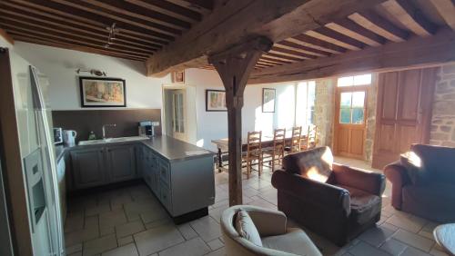 eine Küche und ein Wohnzimmer mit Stühlen und einem Tisch in der Unterkunft GITE Les Aubues in Lormes
