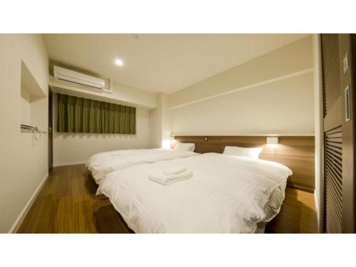 um quarto com 2 camas brancas e uma janela em Lieta Nakayama - Vacation STAY 22439v em Nago