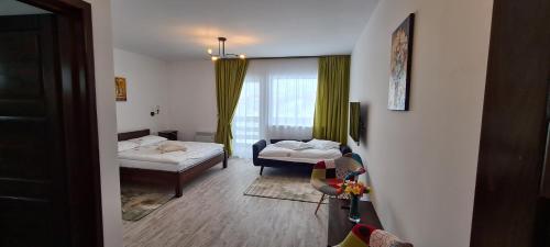 a room with two beds and a living room at Cabana Floare de Colt 2 in Râşnov
