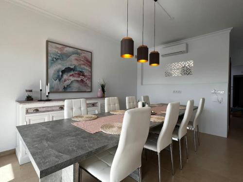 a dining room with a table and white chairs at Casa Sueños in Playa Blanca