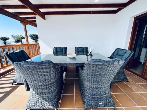 a dining table and chairs on a patio at Lovely Casa Sueños, heated pool x snooker table in Playa Blanca