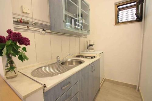 uma casa de banho com um lavatório e um vaso de flores em Two-Bedroom Apartment Crikvenica near Sea 6 em Dramalj