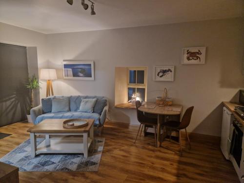 - un salon avec un canapé bleu et une table dans l'établissement Ard Na Mara, Mullaghmore, Sligo, à Mullaghmore
