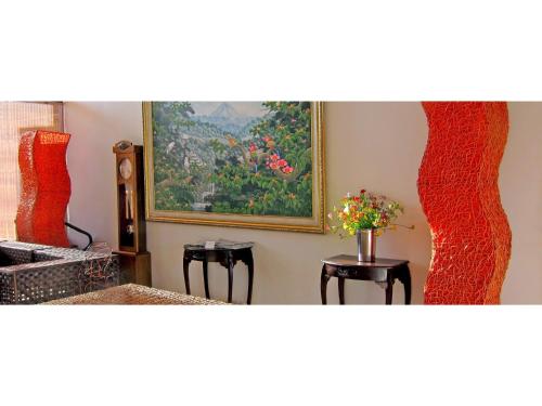Zimmer mit zwei Hockern und einem Gemälde an der Wand in der Unterkunft Hachijojima Hotel Resort Sea Pillows - Vacation STAY 53160v in Mitsune