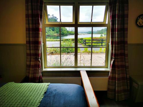 a bedroom with a window with a view of a beach at Old Post Office Studio in Killarney
