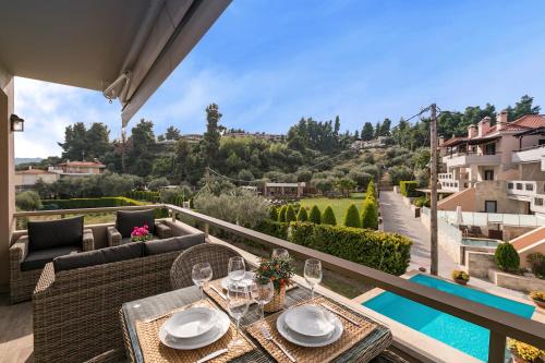 un patio con tavolo e sedie e una piscina di Kassandra Village Resort a Pefkohori