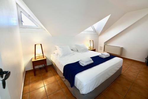 um quarto com uma grande cama branca num sótão em KALIA LODGE em Sainte-Anne