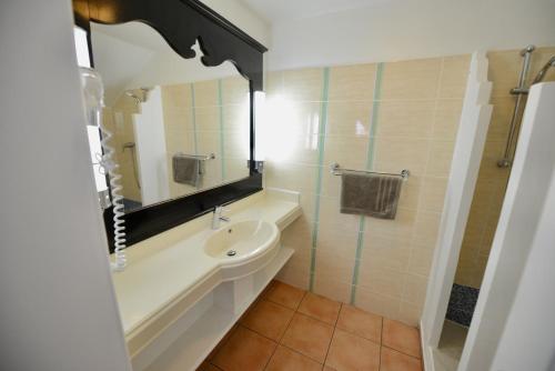 uma casa de banho com um lavatório, um WC e um espelho. em KALIA LODGE em Sainte-Anne