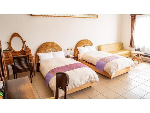 1 dormitorio con 2 camas, mesa y sillas en Hachijojima Hotel Resort Sea Pillows - Vacation STAY 53299v, en Mitsune