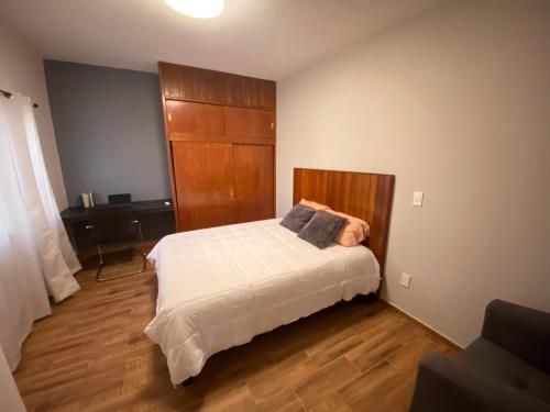 a bedroom with a bed and a desk in it at Departamento Nubes in Tuxtla Gutiérrez