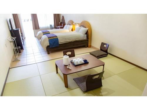 une chambre d'hôtel avec un lit et une table dans l'établissement Hachijojima Hotel Resort Sea Pillows - Vacation STAY 53316v, à Mitsune