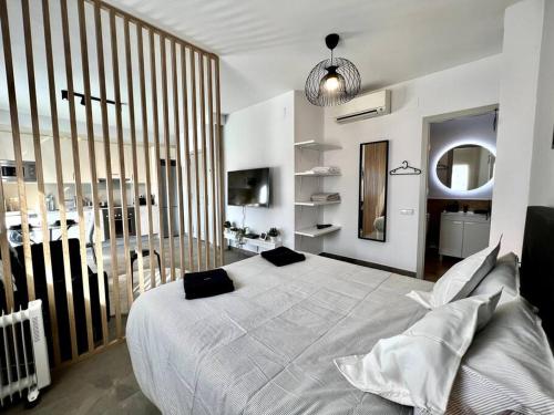 sypialnia z dużym białym łóżkiem z czarnymi poduszkami w obiekcie Loft moderno en buena ubicación w mieście Terrassa
