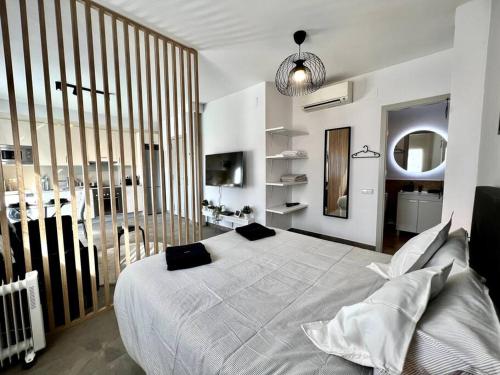 a bedroom with a large white bed with black pillows at Loft moderno en buena ubicación in Terrassa