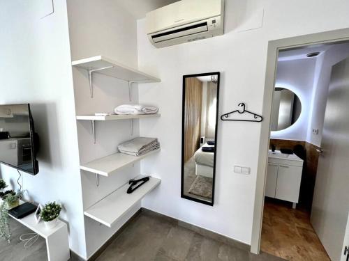 Habitación con estanterías blancas y espejo. en Loft moderno en buena ubicación en Terrassa