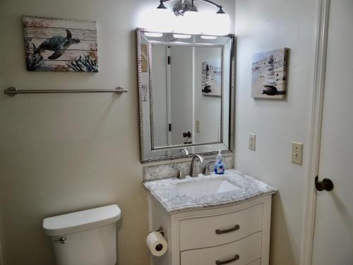 uma casa de banho com um lavatório, um espelho e um WC. em Golf Colony Resort 36F em Myrtle Beach