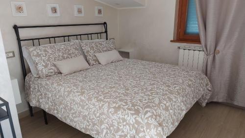 1 cama con 2 almohadas y 1 manta en B&B Ferro di Cavallo, en Tívoli