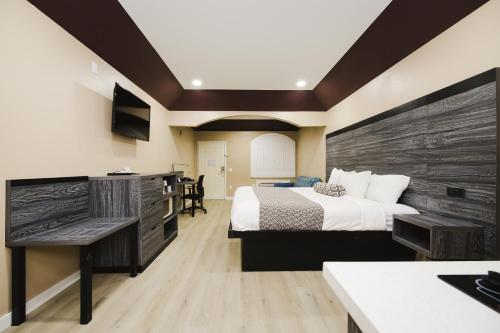 a bedroom with a bed and a wooden wall at Sapphire Inn & Suites in Channelview