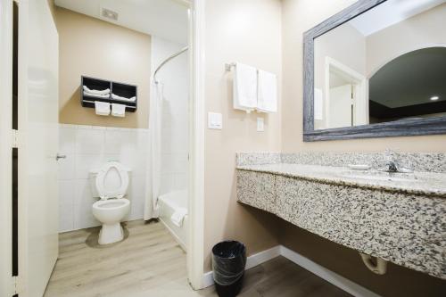 a bathroom with a sink and a toilet at Sapphire Inn & Suites in Channelview