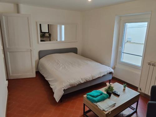 a small bedroom with a bed and a table at Maison 3 chambres 100m du Théâtre Antique avec salle cinéma in Orange