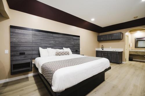 a bedroom with a large bed with a wooden headboard at Sapphire Inn & Suites in Channelview