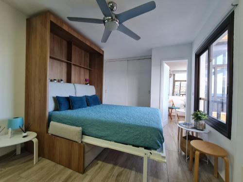 a bedroom with a large bed with blue pillows at Acogedor estudio en Candelaria en primera línea de mar in Candelaria