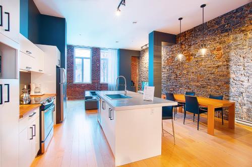 a kitchen and dining room with a brick wall at Les Lofts St-Joseph - Par Les Lofts Vieux-Québec in Quebec City