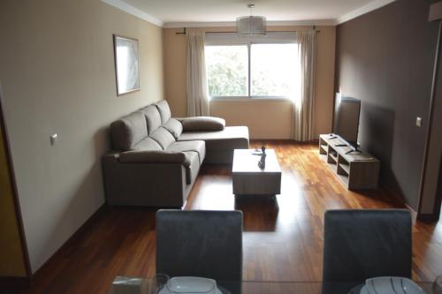 sala de estar con sofá y TV en Apartamento complejo residencial, en Las Palmas de Gran Canaria